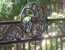 this pool fence adds a decorative hand-hammered casting